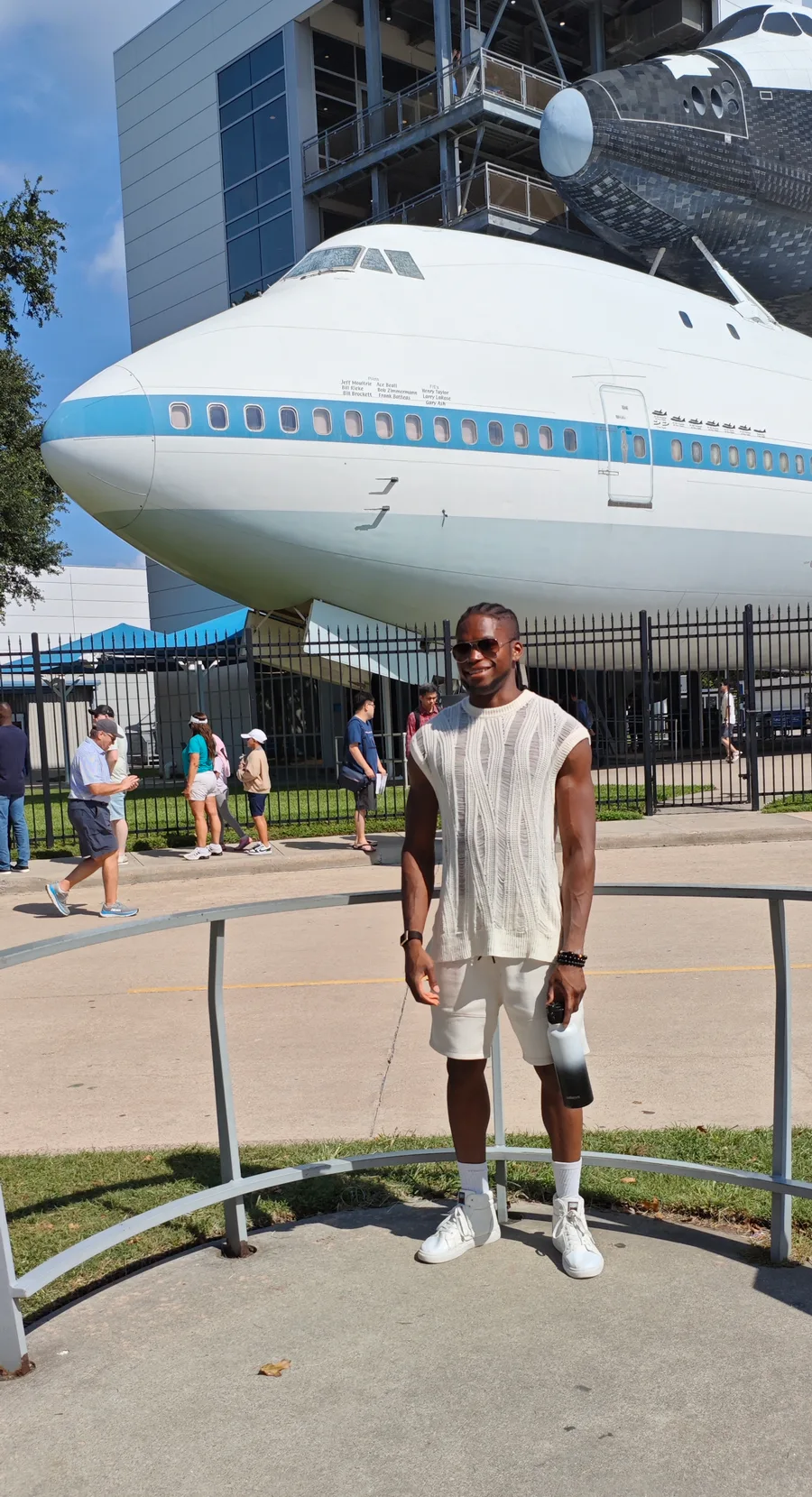 Tomi Adepegba in front of a NASA Space Shuttle and its carrier aircraft at Space Center Houston
